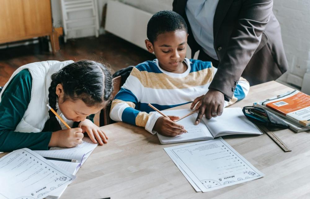 Children sit at a desk 