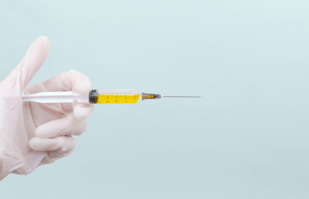 A gloved hand holding a syringe.